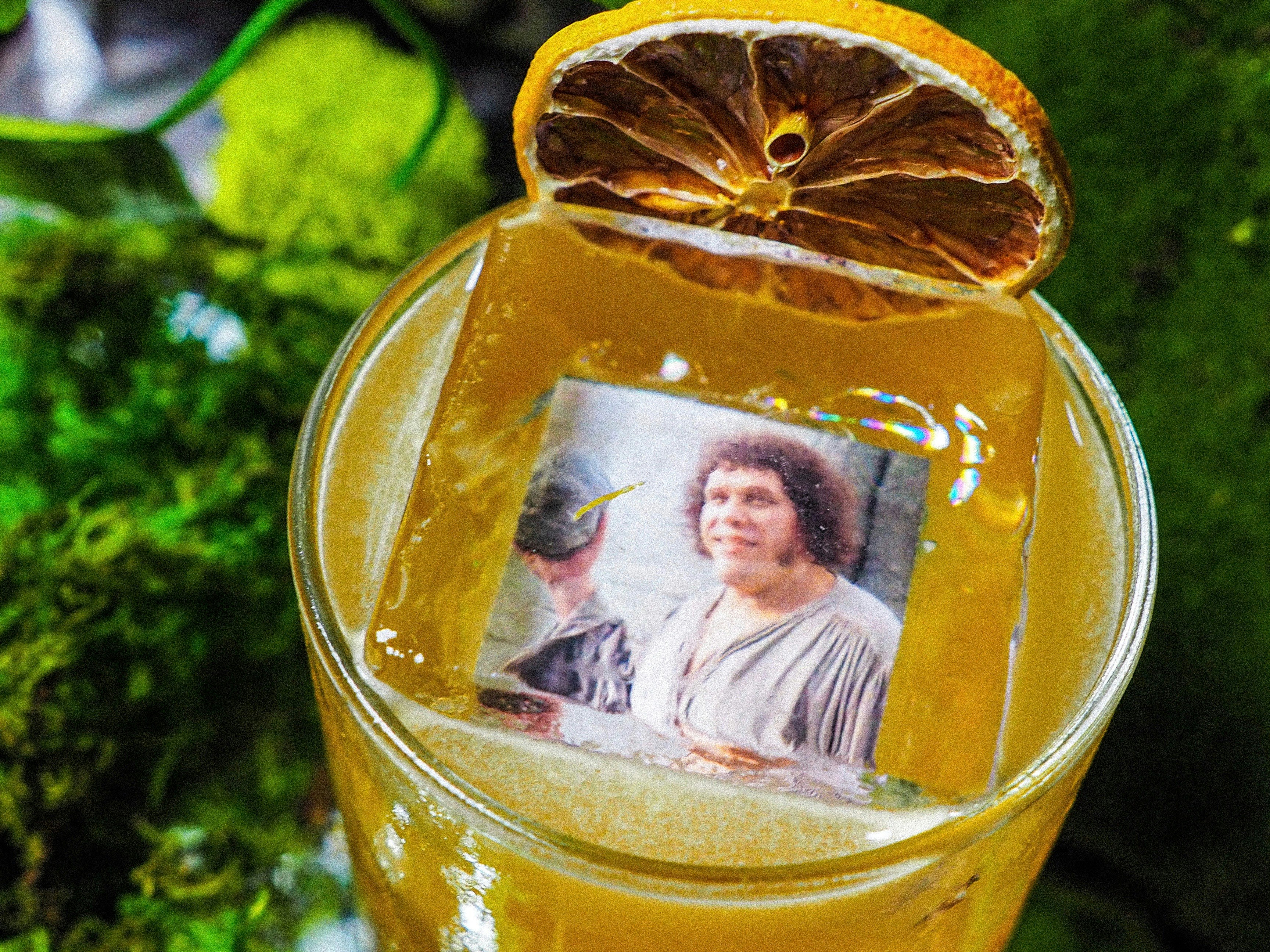 A drink with an ice cube with a picture of André the Giant